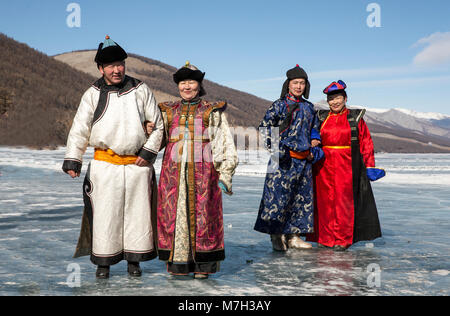 Hatgal, der Mongolei, den 4. März 2018: die Mongolen in traditioneller Kleidung auf einem zugefrorenen See Khuvsgul Stockfoto