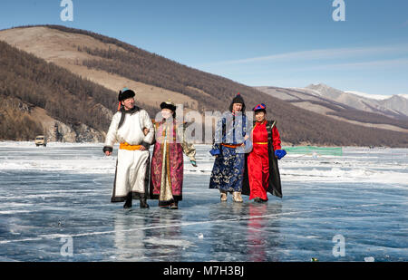 Hatgal, der Mongolei, den 4. März 2018: die Mongolen in traditioneller Kleidung auf einem zugefrorenen See Khuvsgul Stockfoto