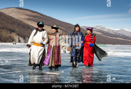 Hatgal, der Mongolei, den 4. März 2018: die Mongolen in traditioneller Kleidung auf einem zugefrorenen See Khuvsgul Stockfoto