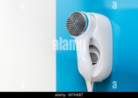 Eine elektrische Fön an der Wand auf blauem Hintergrund angebracht Stockfoto