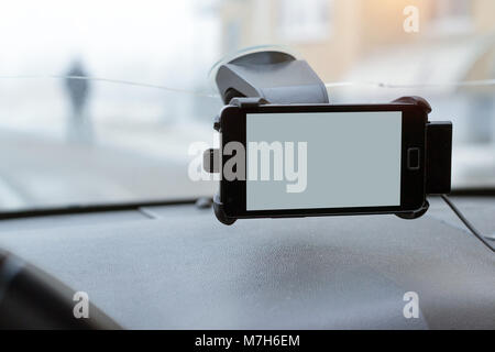 Auto Smartphone Halter mit Telefon an der Windschutzscheibe des Autos befestigt. Zubehör für Fahrzeuge, für ein Auto in der Art und Weise steuern. Telefon holde Stockfoto