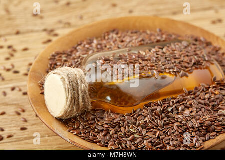Ansicht von oben closeup Bild Leinsamen und Leinöl in einer Glasflasche auf einem hölzernen Hintergrund, geringe Tiefenschärfe. Ernährung und Nahrung für Yo Stockfoto