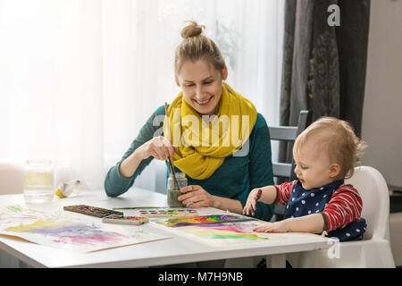 Mutter und Kind malen mit Aquarellfarben zu Hause Stockfoto