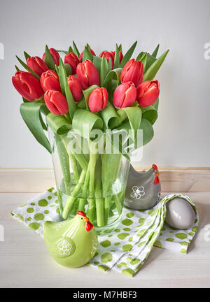 Ostern Hintergrund: Strauß roter Tulpen, Frühling Dekorationen im Landhausstil auf grauen Hintergrund, Text Raum Stockfoto