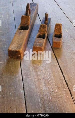 Alte hölzerne Hand Flugzeuge auf Holzboden in leeren Raum innerhalb eines alten 1800s Cottage style Home. Stockfoto