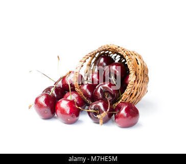 Kirschen in Weidenkorb auf weißem Hintergrund Stockfoto