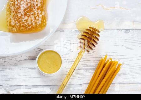 Bio Honig, honig Lippenbalsam und natürlichen Wachs Kerzen auf hölzernen weißen Hintergrund Stockfoto