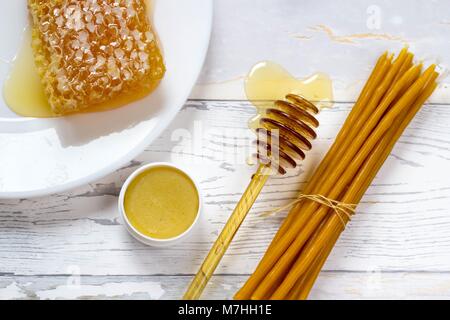 Bio Honig, honig Lippenbalsam und natürlichen Wachs Kerzen auf hölzernen weißen Hintergrund Stockfoto