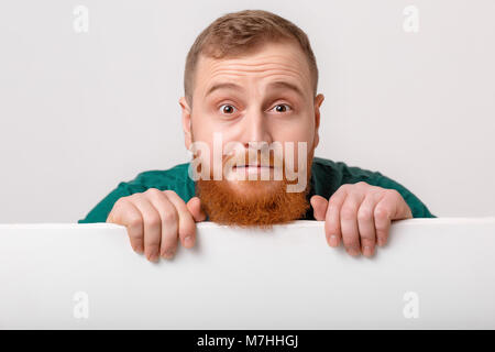 Mann mit Bart mit großen weißen Karte. Stockfoto