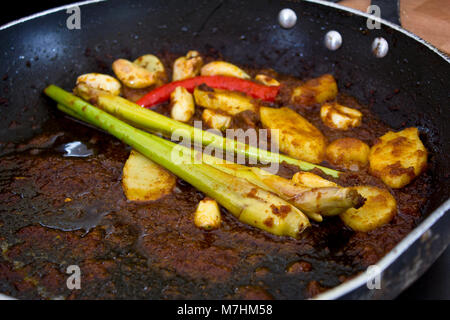 Zitronengras und Ingwer in einer Pfanne im heißen Soße gebraten Stockfoto