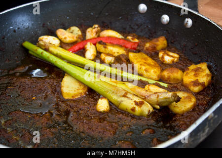 Zitronengras und Ingwer in einer Pfanne im heißen Soße gebraten Stockfoto