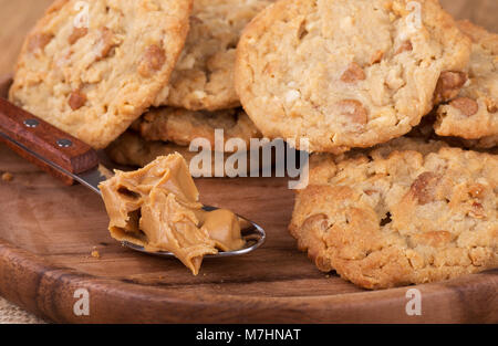 Nahaufnahme von einem Esslöffel Erdnussbutter und ein Haufen von Erdnussbutter Cookies Stockfoto