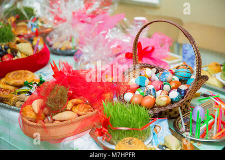 Traditionelle nationale Gebäck, und Tongefäß. Mit nationalen Spezialitäten Gebäck für Novruz Feier in Aserbaidschan. Bemalte Eier im Korb. Kerze. Stockfoto