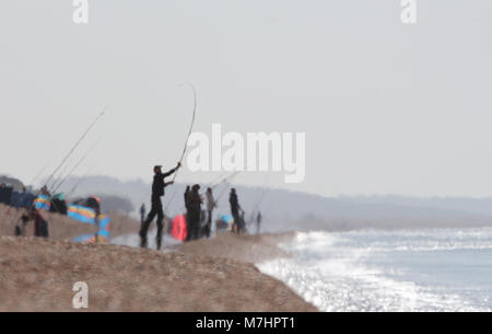 Angler in der Heat Haze an einem heißen Tag am Chesil Beach UK, meist Makrelenfangs Stockfoto