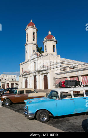 CIENFUEGOS, Kuba - 3. JANUAR 2017: Oldtimer in Jose Marti Park, dem Hauptplatz von Cienfuegos, vor dem Purisima Concepcion Kathedrale. Cie Stockfoto