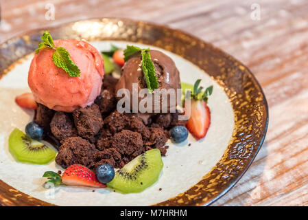 Schokoladen-Brownie mit Eis Eis und Obst Stockfoto
