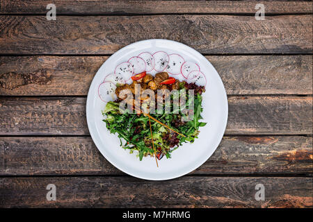 Salat mit Huhn Leber in cremige Sauce mit Pilzen. Stockfoto