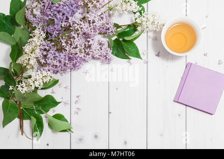 Schönen lila Blüten mit Hinweis - Buch und einer Tasse Tee Stockfoto