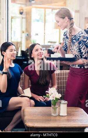 Freundliche Kellnerin Kaffee in ein stilvolles Restaurant mit Stockfoto