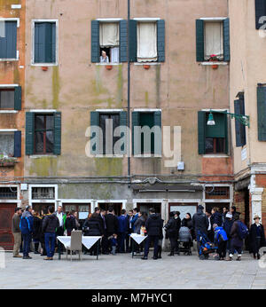 Venedig, Italien. 10. Mär 2018. Mitglieder der jüdischen Gemeinschaft in der Campo del Ghetto Nuovo, während der Sabbat feiern, Tag des Israel Gemeinschaft feiern in Venedig. Das Campo del Ghetto Nuovo in Venedig, im Viertel Cannaregio befindet. Der Campo del Ghetto Nuovo ist das wahre Zentrum der Jüdischen Ghetto von Venedig. Dieses Ghetto war der erste in der Welt und hat seinen Namen von einem bestehenden Gießerei, wo sie geschmolzen oder "warf" der Metalle für den Schiffbau im Arsenal benötigt. Daher auch der Name "Jet" und "Ghetto", in der jeder erkennt jetzt, ein Ort der Trennung. Stockfoto