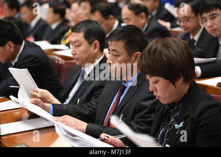 (180311) - Peking, 11. März 2018 (Xinhua) - Mi Zhongyi (2. R, vorne), neu gewählte Stellvertreter des 13. Nationalen Volkskongress (NVK), nimmt an der zweiten Plenarsitzung der ersten Sitzung des 13 NPC in Peking, der Hauptstadt von China, 9. März 2018. Mi Zhongyi ist ein Arbeiter am Getriebe Equipment Company des Nördlichen Heavy Industries Group Co., Ltd. in Shenyang. Er hat sich an die Arbeit, als er das erste Mal die Firma im Jahr 1983 beigetreten sind. Jahre der Praxis und Studium haben ihn zu einem Senior Techniker gedreht. Ein Dutzend seiner Lehrlinge haben auch in technische Experten in der com gewachsen Stockfoto