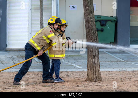 Palamos, Spanien. 10. März, 2018. Fireman Ausstellung auf Dorf Palamos. Kinder s Praxis mit Feuerwehrmann. März 10, 2018, Spanien Quelle: Arpad Radoczy/Alamy leben Nachrichten Stockfoto