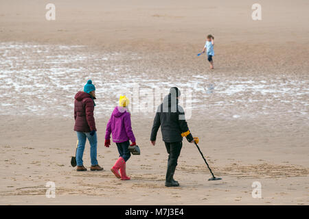 Blackpool, Lancashire. UK Wetter. 11. März, Metall dectorists der Strand für die Archäologie auf der Suche nach Schatz, Ausrüstung, Entdeckung, Geschichte, Sensor, Abenteuer, elektrische durchforsten, suchen, erkennen, der Suche nach verlorenen Gegenständen. Holding detecition Instrument. Credit: MediaWorldImages/Alamy leben Nachrichten Stockfoto