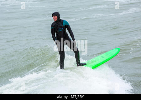 Bournemouth, Dorset, Großbritannien. 11. März 2018. UK Wetter: Grau bewölkten Tag in Bournemouth Strände als Besucher auf dem Meer für Muttertag. SurferCredit: Carolyn Jenkins/Alamy leben Nachrichten Stockfoto