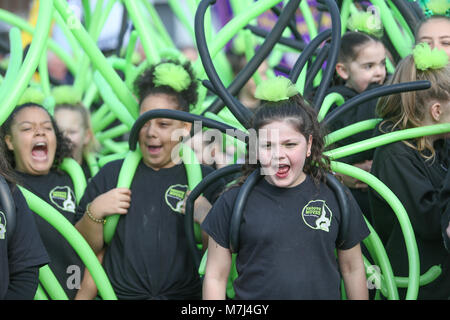 Birmingham's Irish Gemeinschaft feiert St. Patrick's Day mit ihrem jährlichen Parade durch die Straßen der Stadt. Junge Mädchen Tänzer bereiten sich durch Singen und Schreien. Stockfoto