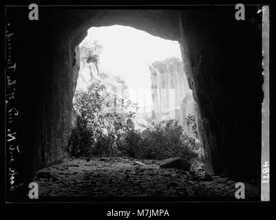 Ein Bild, das den Blick vom El Muzlim-Tunnel in Petra, Wadi Musa, zeigt, mit einem Blick auf die alte Felsenarchitektur am nördlichen Ende der Stadt. Stockfoto