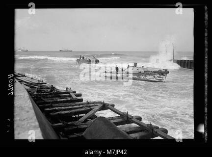 Ein Blick auf den Eingang zum leichteren Becken in Tel Aviv, zeigt die maritime Landschaft und die Docks, an denen Schiffe be- und entladen werden. Dieses Gebiet ist ein wichtiger Bestandteil der Hafeninfrastruktur der Stadt und erleichtert den internationalen Handel und den Transport. Stockfoto