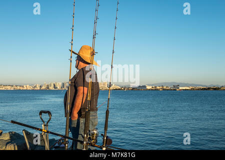 SAN DIEGO, Kalifornien, USA - Mann angeln auf dem Wellenbrecher aus Shelter Island, San Diego Bay an einem sonnigen Tag später Nachmittag. Stockfoto
