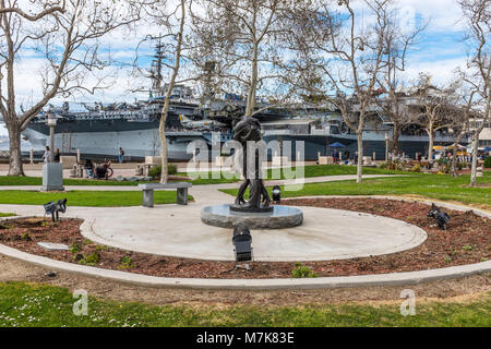 SAN DIEGO, Kalifornien, USA - Die Heimkehr Bronzestatue ehren Service Personal auf Harbor Drive vor der USS Midway Aircraft Carrier Museum. Stockfoto