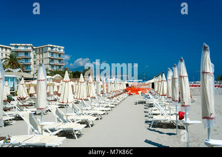 Alassio, Ligurien, Italien - 20. Mai 2019: Strand in Albenga Italien mit Liegestühlen und Sonnenschirmen an einem heißen Sommertag Stockfoto