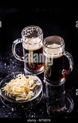 Becher mit Bier auf Tisch Stockfoto