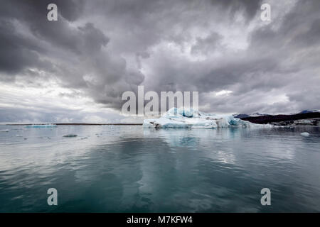 Dramatische Wolken im eisigen Wasser aus dem Vatnajokul Gletscher vom Boot auf See Jokulsarlon, Island wo Eisberge ins Meer schwimmen Rechnung Stockfoto