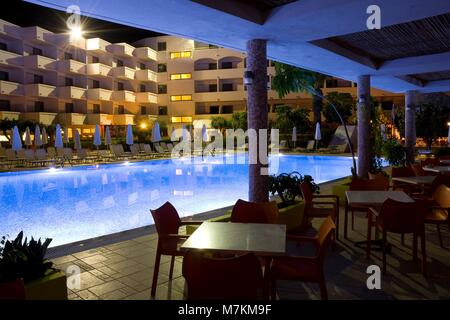 IALYSSOS, Griechenland - 03.Mai: Cafe und beleuchtetes Schwimmbad von Ialyssos Bay Hotel bei Nacht am 03.Mai 2016 in Ialyssos, Griechenland Stockfoto