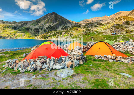 Wunderschönen alpinen Campingplatz mit bunten Zelte in der Nähe von bucura Gletschersee. Atemberaubende Berg Campingplatz in Retezat Nationalpark, Karpaten, Transy Stockfoto