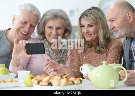 Zwei ältere Ehepaare nehmen selfie mit Smartphone beim Trinken Stockfoto