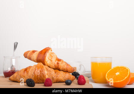 Hausgemachte Croissants auf ein Frühstück mit frischem Obst, Saft und Kaffee und frisches Obst. Stockfoto