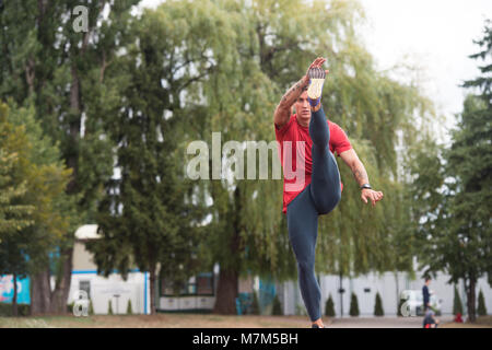 Junge Athlet Mann Entspannen und Strech Bereit für Laufen bei Leichtathletik Rennstrecke auf Stadium Stockfoto