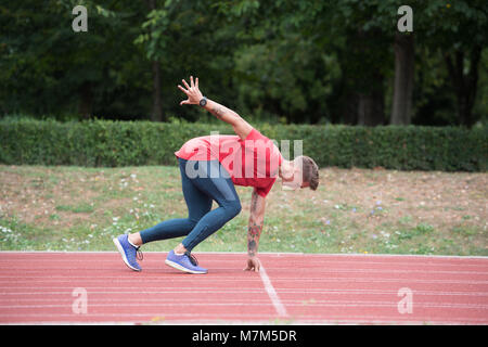 Sprinter Mann laufen auf roten Spuren Spuren in der Leichtathletik Stadion in High Speed Top View Stockfoto