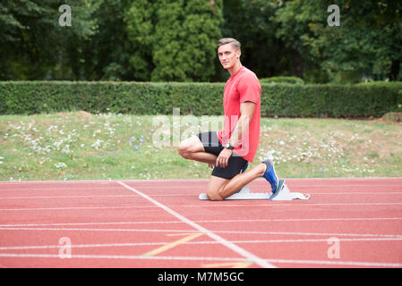Sprinter Mann laufen auf roten Spuren Spuren in der Leichtathletik Stadion in High Speed Top View Stockfoto