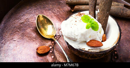 Eis mit Mandeln und Zimt Geschmack in eine Kokosnuss Schale Stockfoto