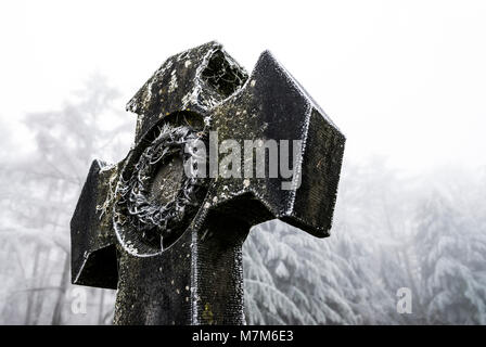 Geheimnisvolle belgischen Friedhof am Waldrand im Winter mit Frost, Eis und Schnee auf den Gräbern Stockfoto