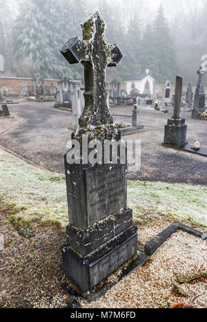 Geheimnisvolle belgischen Friedhof am Waldrand im Winter mit Frost, Eis und Schnee auf den Gräbern Stockfoto