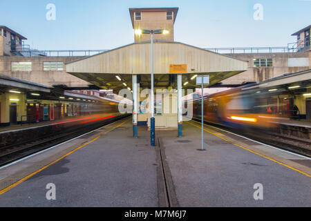 Bahnhof in Woking, Surrey mit Zügen Sturm über die Plattformen, die auf ihrem Weg von und nach London Stockfoto