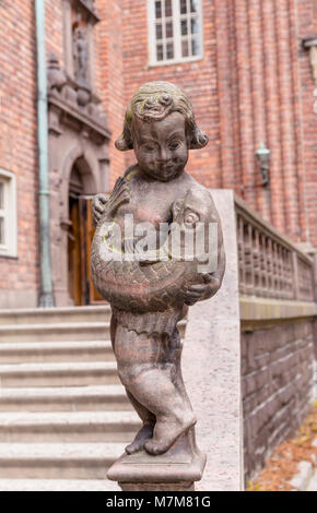 Die Skulptur eines Jungen mit einem Fisch im Hof von Stockholm City Hall. Schweden Stockfoto