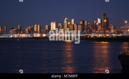 Gold Licht schimmert das Wasser reflektiert beleuchteten Gebäuden in der Innenstadt von Seattle Stockfoto