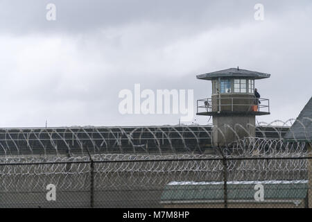 Ein bewaffneter Wachmann Umfragen das Gelände von der Reling eines Gefängnisses Wachtturm Stockfoto